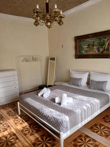 a bedroom with a bed with white sheets and a chandelier at Chrysafenia's House in Mandrákion