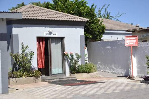 a white house with a sign in front of it at Kgajane Guest House in Molepolole
