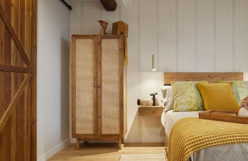 a bedroom with a bed and a wooden closet at ALTZOAN Apartamentos Turísticos y aparcamiento gratuito in Zarautz