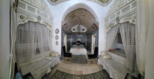 a bedroom with a bed and two chairs in it at Dar EMNA in Kairouan