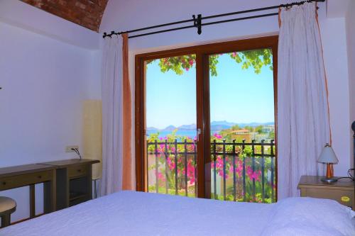 a bedroom with a bed and a large window at Munahan Otel in Bodrum City