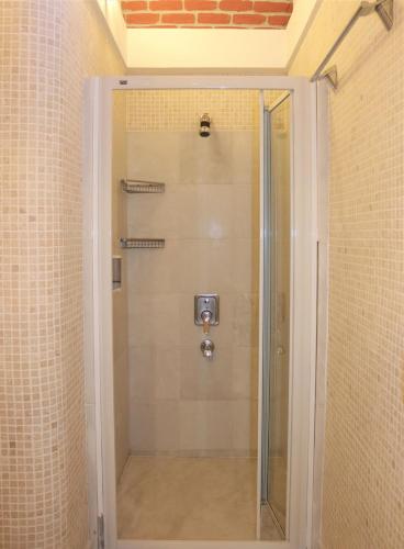 a shower with a glass door in a bathroom at Munahan Otel in Bodrum City