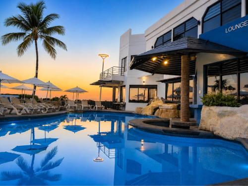 a pool in front of a building with a resort at Olas Altas Inn Hotel & Spa in Mazatlán
