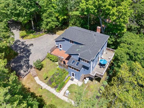 an overhead view of a blue house with trees at Serene waterfront home w/ a dock, large deck & amazing views! in Dyer Cove