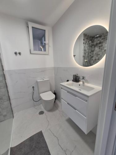 a bathroom with a toilet and a sink and a mirror at Playa Los Náufragos Torrevieja in Torrevieja