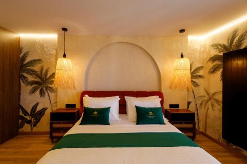 ein Schlafzimmer mit einem Bett mit grünen und weißen Kissen in der Unterkunft Hotel Guardamar in Guardamar del Segura