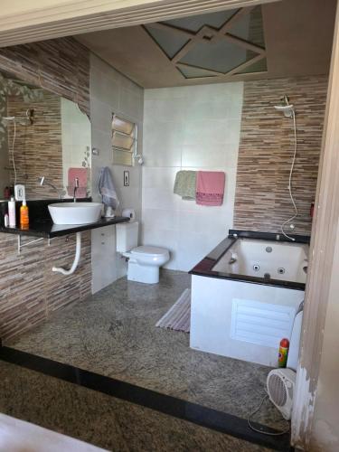 a bathroom with a tub and a sink and a toilet at momento de paz in Sumaré