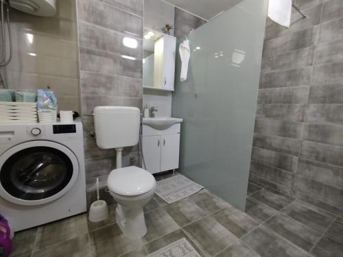 a bathroom with a toilet and a washing machine at Sky Vista in Železnička Stanica Tuzla