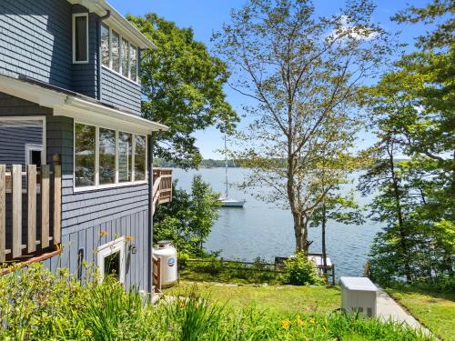 a house with a view of a body of water at Serene waterfront home w/ a dock, large deck & amazing views! in Dyer Cove
