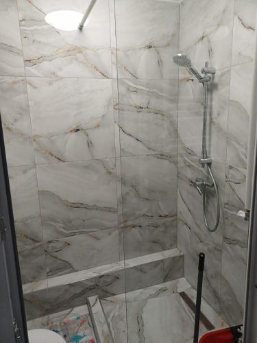 a bathroom with a shower with a marble wall at Ibo in Brăila