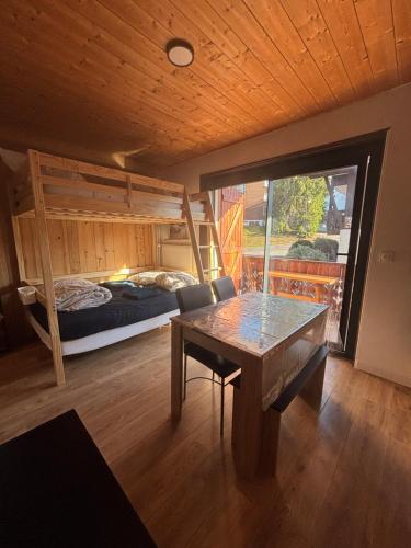a room with a table and a bed and a bedroom at KEARL, studio neuf soleil et détente in Les Gets