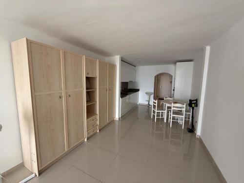 a kitchen and dining room with wooden cabinets and a table at AwayDays - 72 - Ocean View Studio in Empuriabrava