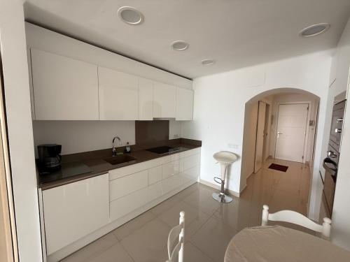 a white kitchen with a sink and a counter at AwayDays - 72 - Ocean View Studio in Empuriabrava