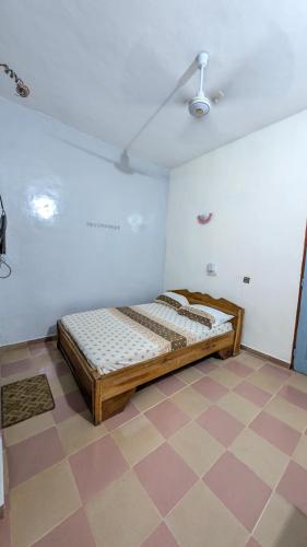 a bed in a room with a checkered floor at Hôtel St Jo in Bohicon