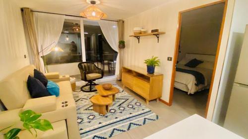 a living room with a couch and a bedroom at Distrito Cavancha in Iquique