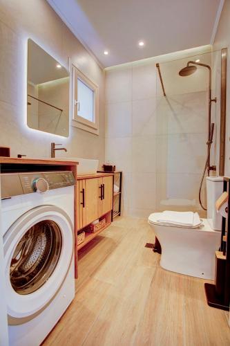 a bathroom with a washing machine and a toilet at Nyfida's four waves in Nifida