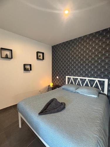 a bedroom with a large bed with a gray headboard at Foch F1 N7 in Le Creusot
