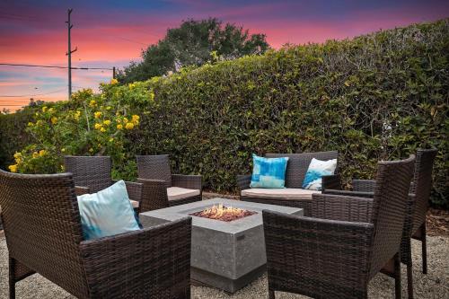 a patio with wicker chairs and a fire pit at Bella Luna in Carpinteria