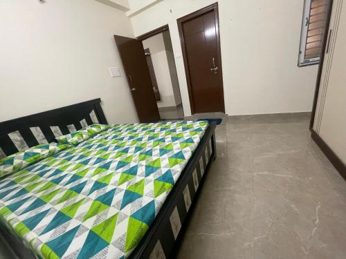 a bedroom with a bed with a quilt on it at Narayana Avenue , kondapur 2 Bhk in Hyderabad