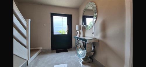 a bathroom with a mirror and a sink and stairs at Suzies Escape in Bovevagh