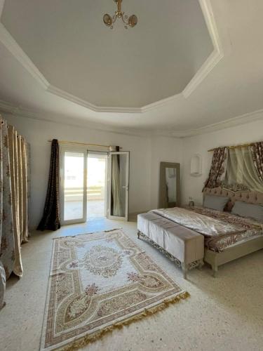 a large bedroom with a bed and a rug at Dar Souleyman in Midoun