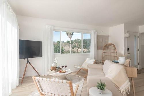 a living room with a white couch and a tv at Bella Surf in Avila Beach