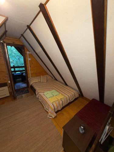 a attic room with two beds and a table at Ovčar Banja in Čačak