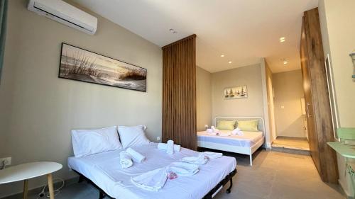 a hotel room with two beds and a bathroom at Magdalena Elegant Studios in Neoi Epivates
