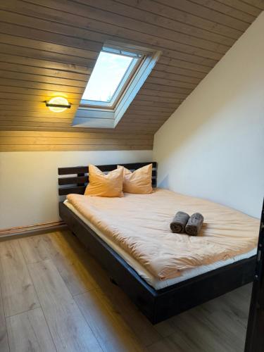 a bedroom with a bed with two shoes on it at Csodaszarvas Erdeiház in Borzont