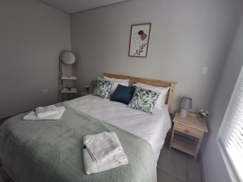 a bedroom with a large bed with a green blanket at SafeHaven 45 in George