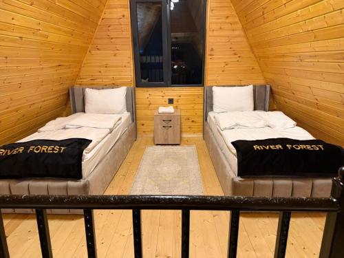 ein Zimmer mit zwei Betten in einer Holzhütte in der Unterkunft Rıver Forest Hotel in İsmayıllı