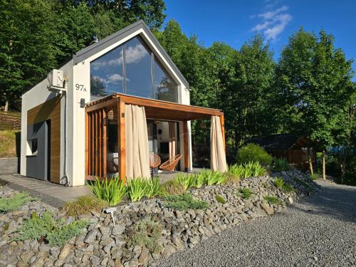 a small house with a glass door on a rock at Nad Strumieniem in Pieszyce