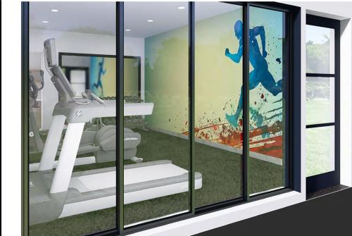 a room with a gym with a treadmill and a mural at Days Inn by Wyndham Encinitas Moonlight Beach in Encinitas