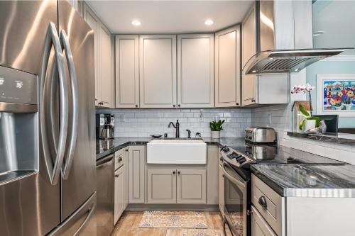 a kitchen with white cabinets and a stainless steel refrigerator at Carpinteria Shores CS 110 in Carpinteria