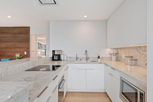 a white kitchen with white cabinets and a sink at Carpinteria Shores CS 107 in Carpinteria