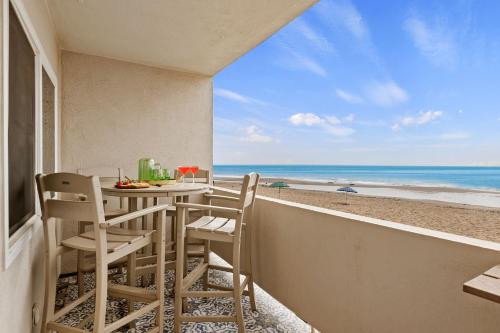 a balcony with a table and chairs on the beach at Carpinteria Shores CS 209 in Carpinteria