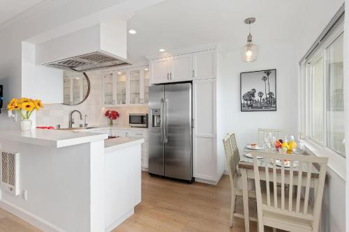 a kitchen with white cabinets and a stainless steel refrigerator at Carpinteria Shores CS 209 in Carpinteria