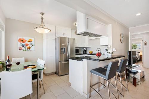 a kitchen with white cabinets and a table with chairs at Carpinteria Shores CS 212 in Carpinteria
