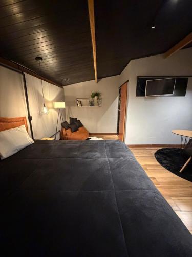 a bedroom with a large black bed in a room at Chalé Exclusive El Paso in Mairiporã