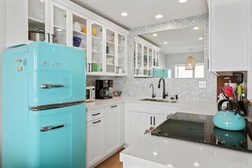 a blue refrigerator in a kitchen with white cabinets at Carpinteria Shores CS 206 in Carpinteria