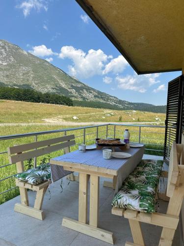 a picnic table and two benches on a balcony with a view at Family house, Savin kuk in Žabljak
