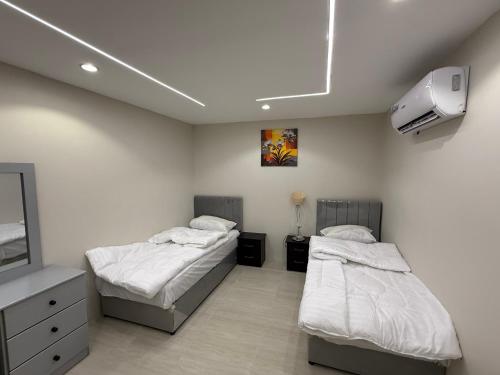 a bedroom with two beds and a tv at الشروق in Al Baha