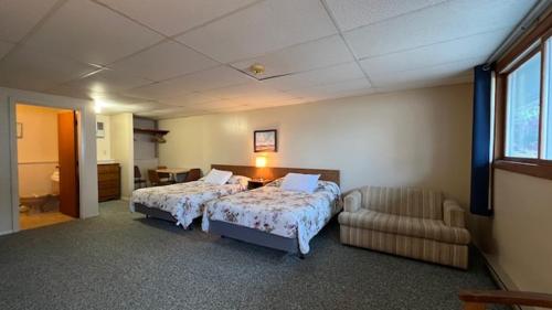 a bedroom with two beds and a couch and a chair at Inn Between the Beaches & Villager in York Beach