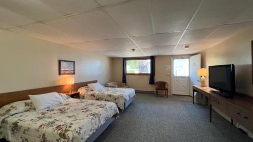 a hotel room with two beds and a flat screen tv at Inn Between the Beaches & Villager in York Beach