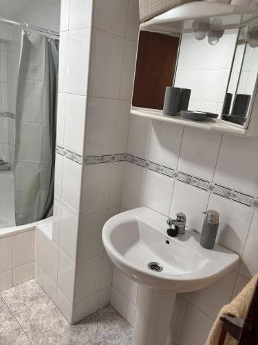 a white bathroom with a sink and a shower at Santa Cruz del sil in Santa Cruz del Sil