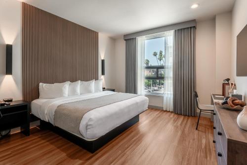 a hotel room with a bed and a window at Kins Hotel in Los Angeles