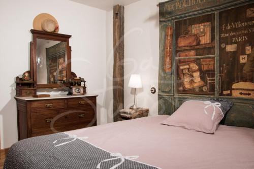 Schlafzimmer mit einem Bett, einer Kommode und einem Spiegel in der Unterkunft Chez les Goyp in Cosges