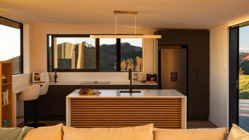 a kitchen with a island in the middle of a room at The Hide Kapiti Accommodation in Paraparaumu