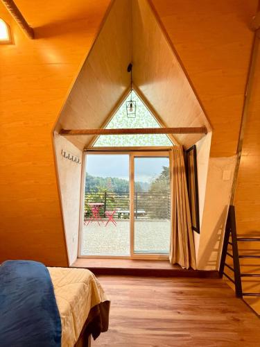 a room with a large window in a tiny house at Cabaña, fogata, terraza in Santiago Sacatepéquez
