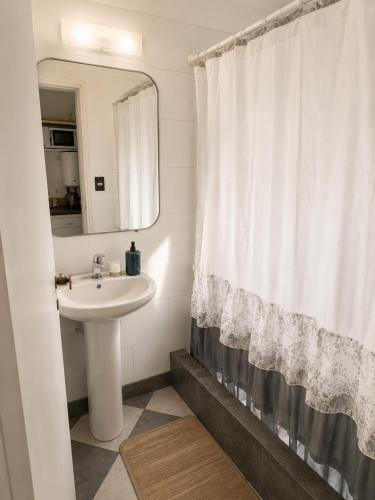 a bathroom with a sink and a shower curtain at Despertá frente al mar! Loft con bajada privada! in Santa Clara del Mar